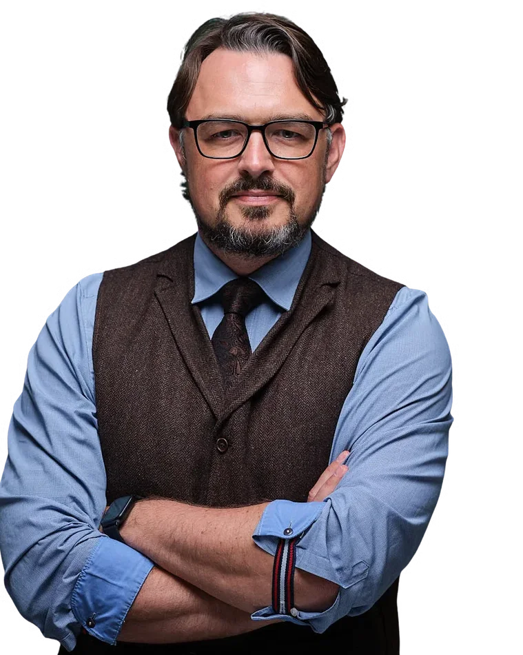 Holger Heinze mit verschränkten Armen, Brille, blauem Hemd und brauner Weste